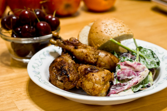 Grilled Chicken Drumsticks, Salad, Bread, and Cherries