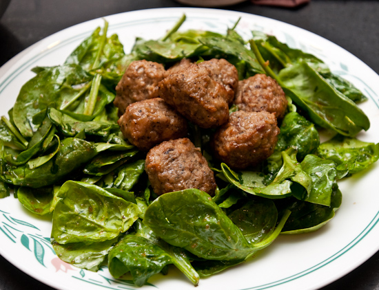 Aidell's meatballs on a wilted spinach salad