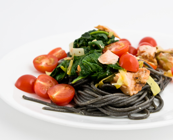 Squid ink spaghetti tossed in olive oil, garlic, and leeks topped with reheated left over salmon and spinach with fresh cherry tomatoes